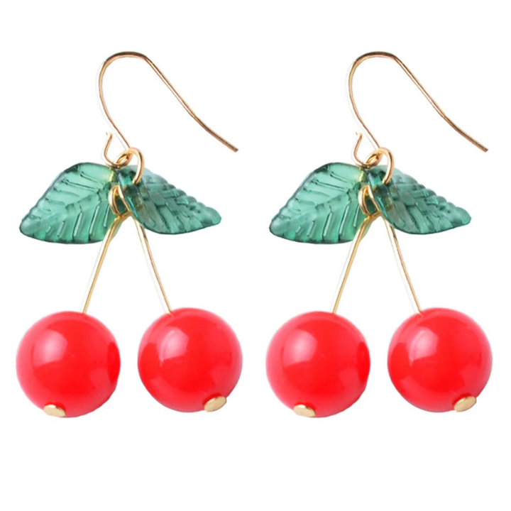 Cherry Earrings – Cute Y2K and Retro Aesthetic Jewelry. A pair of dangling earrings with translucent green leaf charms and three glossy red cherry beads hanging from gold-tone hooks.