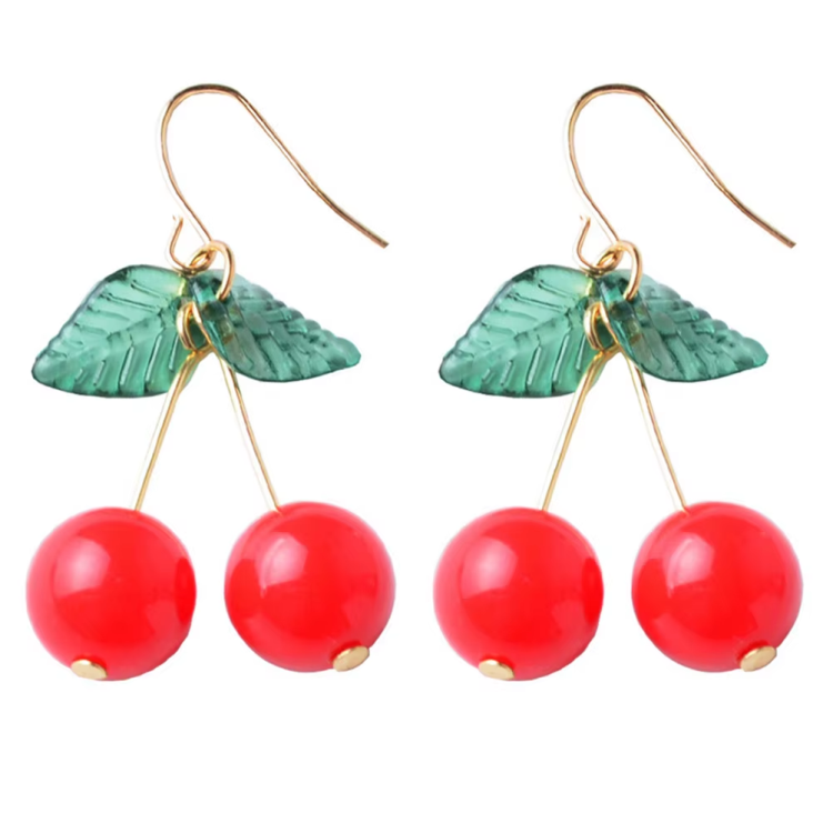 Cherry Earrings – Cute Y2K and Retro Aesthetic Jewelry. A pair of dangling earrings with translucent green leaf charms and three glossy red cherry beads hanging from gold-tone hooks.