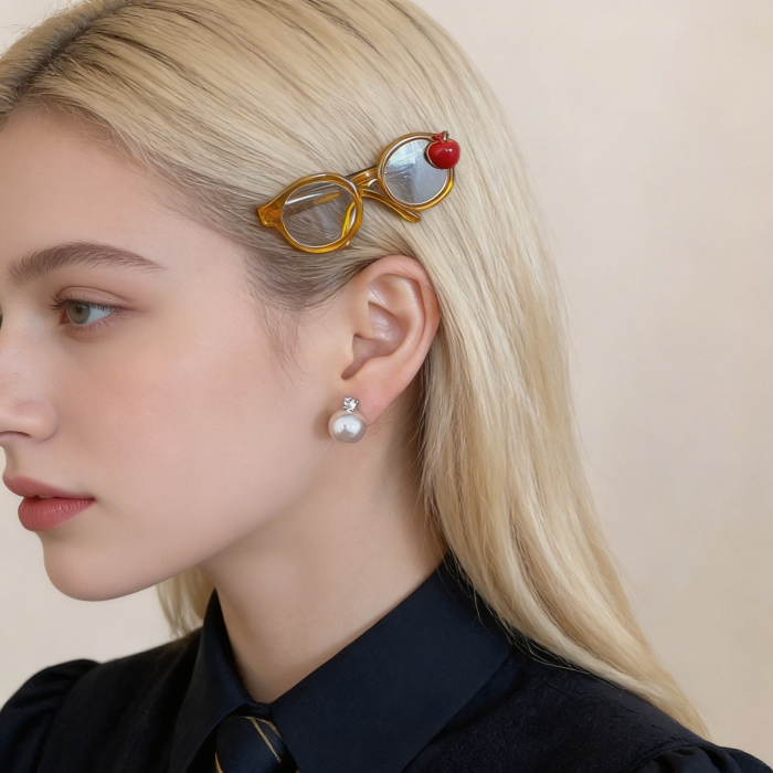 Woman with a unique hair accessory resembling glasses with an apple on top, wearing a black shirt.