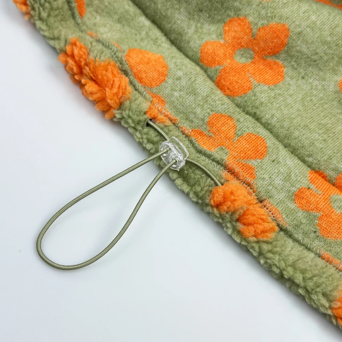Green fabric with orange floral patterns on a white background