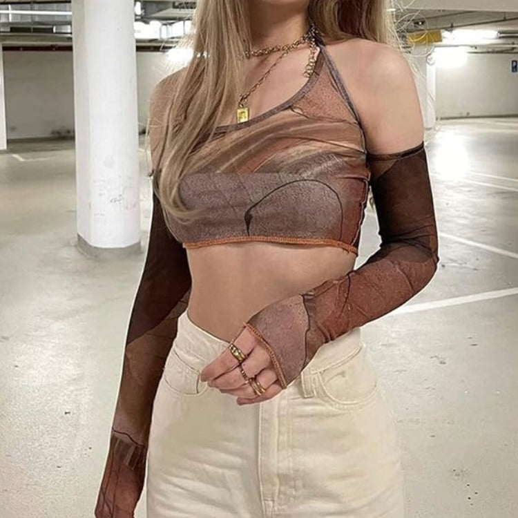 Brown Y2K Halter Crop Top - Brown Y2K Alternative Crop Top. A woman wearing a sheer brown and taupe mesh long-sleeve crop top with a scoop neckline, styled with cream-colored jeans in a parking garage.