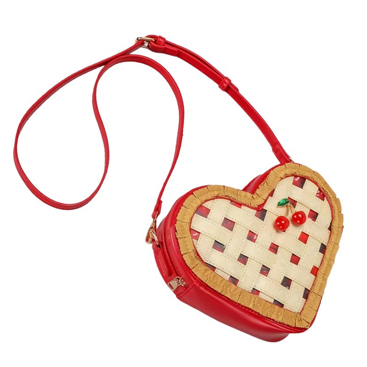 Heart Shaped Woven Handbag – Cute Coquette Aesthetic Purse. A heart-shaped crossbody bag designed like a cherry pie crust, featuring a red faux leather body, a woven beige and red lattice pattern, and two small red cherries on the front, shown on a plain white background.