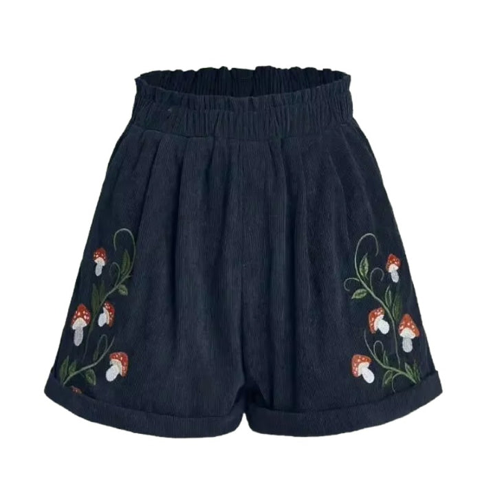 Cottagecore Mushroom Shorts – Cottagecore Aesthetic Clothing. Dark navy corduroy shorts with embroidered red and white mushrooms and green vines on the front, featuring an elastic waistband and rolled cuffs.